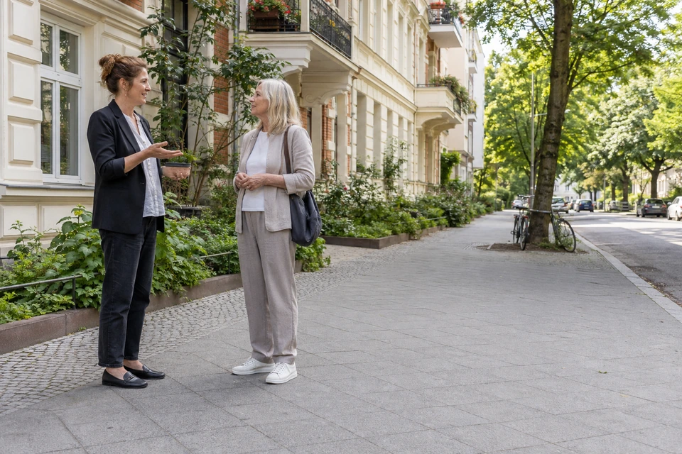 Symbolischer Immobilienkontakt vor einem Berliner Mehrfamilienhaus